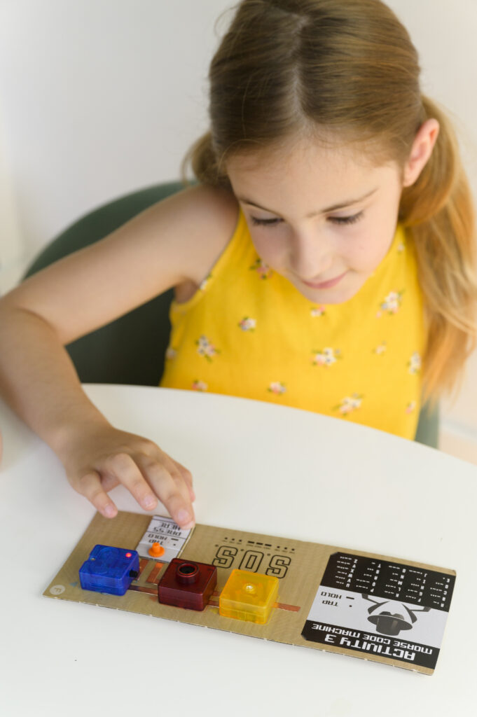 Happy child playing with the finished product from our 4M TechCraft Paper Circuit Science